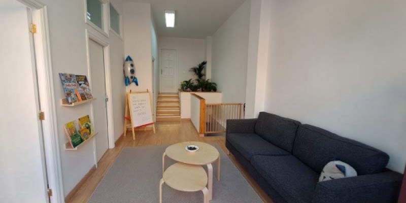 Sala recibidor de las instalaciones, con mesita y sofá