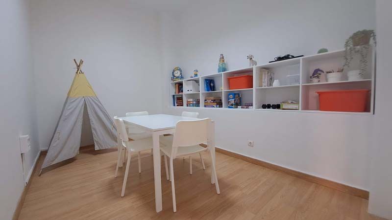 Sala con una mesa, armario de juegos y una tienda de campaña tipo india