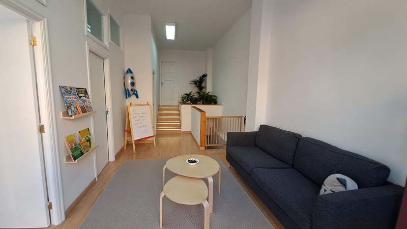 Sala recibidor de las instalaciones, con mesita y sofá