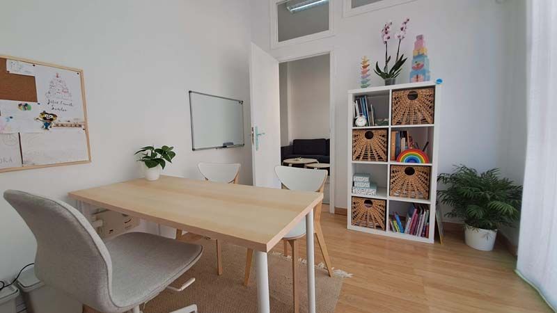 Sala con una mesa y sillas desde la perspectiva de salida de la misma