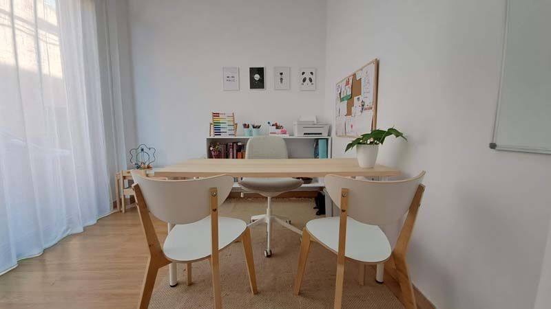 Sala con una mesa y sillas desde la perspectiva de entrada a la misma