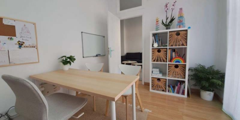 Sala con una mesa y sillas desde la perspectiva de salida de la misma